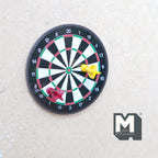 1:12 scale miniature magnetic dart board with 2 darts, set of 3, black board with red and yellow darts, shown on a wall