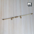 1:12 scale miniature brass curtain rod in gold with 10 rings and 2 hangers, fixed length, shown on a wood surface