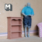 1:12 scale miniature scalloped bookcase with 3 shelves in dusty rose, shown beside an artist figure