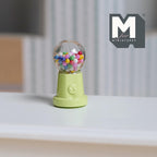 1:12 scale miniature metal tabletop gumball machine in pastel green with colorful gumballs, non working, shown on a white table