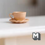 1:12 scale miniature tea cup and scalloped saucer in peach, set of 2, shown on a white table
