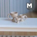 1:12 scale miniature footed pedestal mugs in beige, set of 3 graduated sizes, shown on a white table