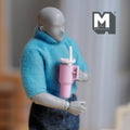 1:12 scale miniature tumbler with straw and handle in pink, held by a figure for scale