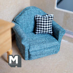 1:12 scale miniature upholstered armchair in teal blue woven fabric with a black and white houndstooth cushion