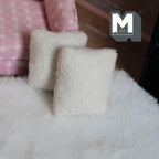 1:12 scale miniature plush throw pillows in cream, set of 2, soft square cushions shown on a white fluffy rug