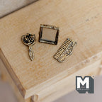 1:12 scale miniature vanity mirror, comb and brush set in antique gold, set of 3 with ornate detail, on a wood table