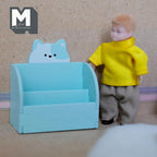 1:12 scale miniature wood cat 2 tier bookshelf kit in light blue with a cat face back, assembled, beside a boy doll