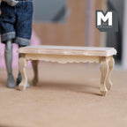 1:12 scale miniature coffee table bench with cabriole legs in bare wood, scalloped apron, shown beside a posable figure