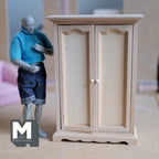 1:12 scale miniature paneled wardrobe armoire in bare wood, style B, two arched panel doors, shown beside a posable figure