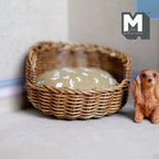 1:12 scale miniature wicker pet bed in brown with a beige floral cushion, shown beside a dog figurine