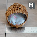1:12 scale miniature hooded wicker pet bed in brown with a top handle and light blue floral cushion, shown with a ruler