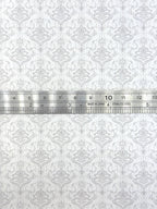 1:12 scale miniature scrollwork damask peel and stick wallpaper in white and gray, repeating motif shown with a ruler