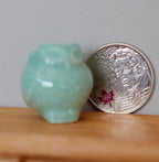 1:12 scale miniature clay owl planter in mint green, shown on a wood shelf beside a coin for scale