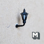 1:12 scale miniature lantern style wall sconce in black, non working, white panes on a curved arm, mounted on a wall