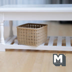1:12 scale miniature square faux wicker basket in beige with an open grid weave, shown on a white shelf