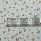 1:12 scale miniature small floral and jars wallpaper in white with pink flowers, green leaves and tiny jars, shown with a ruler