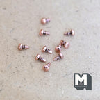 1:12 scale miniature small glossy cabinet knobs in rose gold, set of 10, shown scattered on a tan surface
