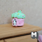 1:12 scale miniature fairy mushroom house with white bunny, green roof and pink base, shown on a wood dresser