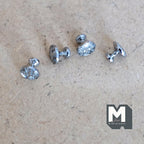 1:12 scale miniature glossy medallion cabinet knobs in silver, set of 4, embossed round faces on a tan surface