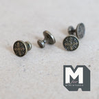 1:12 scale miniature matte medallion cabinet knobs in antique bronze, set of 4, embossed round faces, close view