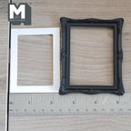 1:12 scale miniature ornate picture frame with mat in black, large, carved corners, shown with a white mat and ruler