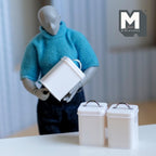 1:12 scale miniature square kitchen canisters with labels in white, set of 3, lids with wire handles, held by a posable figure