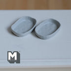1:12 scale miniature irregular textured plates in cool gray, style A, set of 2, rounded rectangle shape on a white table