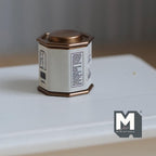 1:12 scale miniature octagonal tea tin with lid in white with a printed label and copper tone lid, on a white table