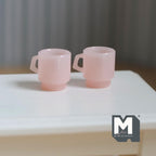 1:12 scale miniature retro diner stacking mugs in pink, set of 2, translucent with D handles, on a white table