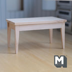 1:12 scale miniature wood dining table in bare wood, rectangular top with tapered legs, shown on a wood floor