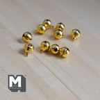 1:12 scale miniature globe bells in gold, set of 10, small round bells with loops shown on a light wood surface