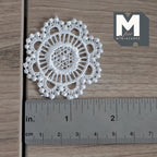 1:12 scale miniature round lace doily in white with scalloped openwork edge, shown with a ruler