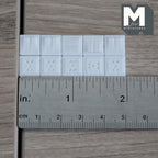 1:12 scale miniature wall outlets and switch plates in white, non working, set of 10, shown in two rows with a ruler