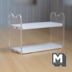 1:12 scale miniature acrylic 2 tier bookshelf with white wood shelves and clear side panels, on a wood floor