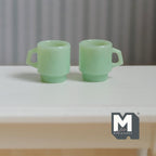 1:12 scale miniature retro diner stacking mugs in jade green, set of 2, translucent with D handles, on a white table