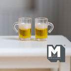 1:12 scale miniature resin clear beer mugs with foam, set of 2, filled with golden beer, shown on a white table