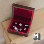 1:12 scale miniature jewelry box in brown with red velvet lining, opening lid and faux diamonds, on a wood table