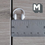 1:12 scale miniature over ear headphones in white, non working, padded ear cups and headband, shown with a ruler