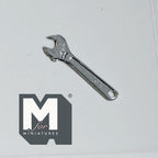 1:12 scale miniature metal adjustable wrench in shiny silver, shown from above on a light gray surface