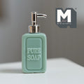 1:12 scale miniature soap pump bottle in sage green with silver pump and raised pure soap lettering, on a white table