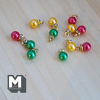 1:12 scale miniature pearlescent Christmas baubles in red, yellow and green with gold caps, set of 12, on a wood floor