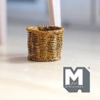 1:12 scale miniature woven look planter pot in golden brown resin, round basket texture, shown on a wood floor