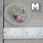 1:6 scale miniature woven straw hat with pink roses and green leaves, wide open weave brim, shown with a ruler