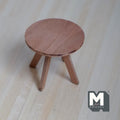1:12 scale miniature wood round coffee table in brown with splayed legs and cross brace, shown on a wood floor