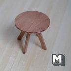 1:12 scale miniature wood round coffee table in brown with splayed legs and cross brace, shown on a wood floor