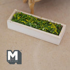 1:12 scale miniature wood planter box with yellow flowers and greenery, window box style, shown on a tabletop