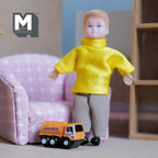 1:12 scale miniature toy fuel tanker truck in orange resin with black wheels, shown on the floor beside a doll