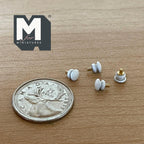 1:12 scale miniature metal door knobs with rosettes in white with brass stems, set of 4, shown beside a coin