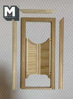 1:12 scale miniature louvered saloon doors in bare wood with frame and back trim pieces, shown on patterned wallpaper