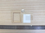 1:12 scale miniature wood photo frame in bare wood with clear glazing and white backing, shown with a coin and ruler